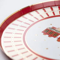 Angle view of plate rim showing red and gold details around the train design.