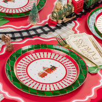 Angle place setting showing train plate with ticket card and gold fork near the tracks.