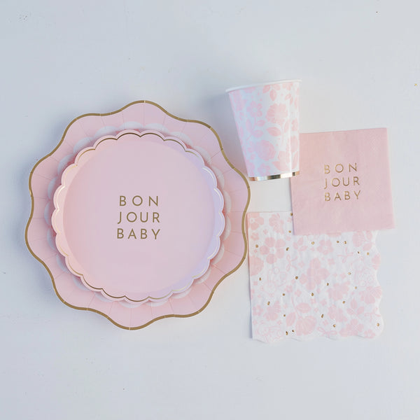 Stack of blush pink scalloped dessert plates with gold edging for baby girl shower.