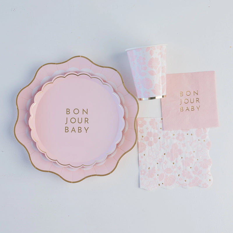 Stack of blush pink scalloped dessert plates with gold edging for baby girl shower.