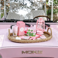 Rattan tray on pink vehicle hood filled with Camp Bachelorette flex cups and lantern décor