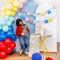 Woman in red sweater posing with cat next to table set with Cat Party Table Runner and banner