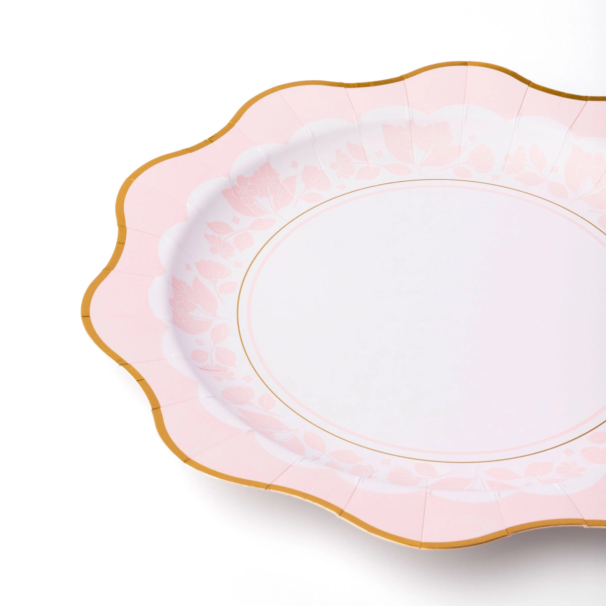 Mixed tableau of pink and blue floral plates for gender‑reveal garden tea.