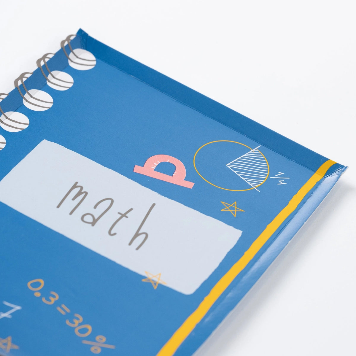 Close-up of blue notebook-shaped plate labeled ‘Math’ with doodle graphics.