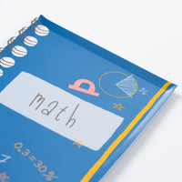 Close-up of blue notebook-shaped plate labeled ‘Math’ with doodle graphics.