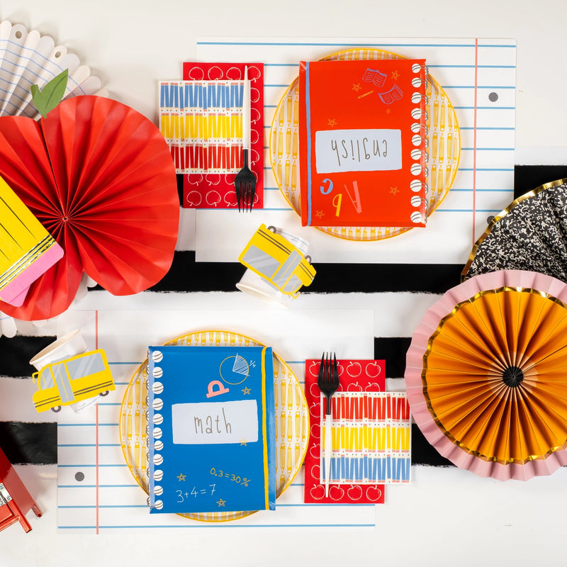 Overhead shot of full tablescape featuring red and blue notebook plates and school décor.