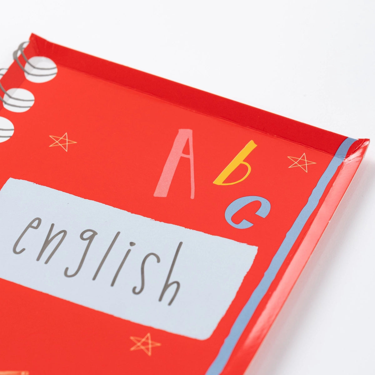 Close-up of red notebook-shaped plate labeled ‘English’ with spiral detail.
