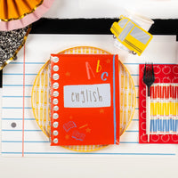 English notebook plate displayed on pencil plate with apple guest towel and school bus cup.