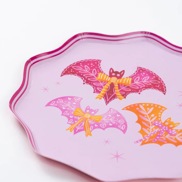 Center view of pink Halloween dinner plate with three bats and bows artwork.