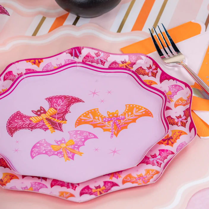 Place setting with layered pink dinner plate and coordinating border plate on a striped runner.
