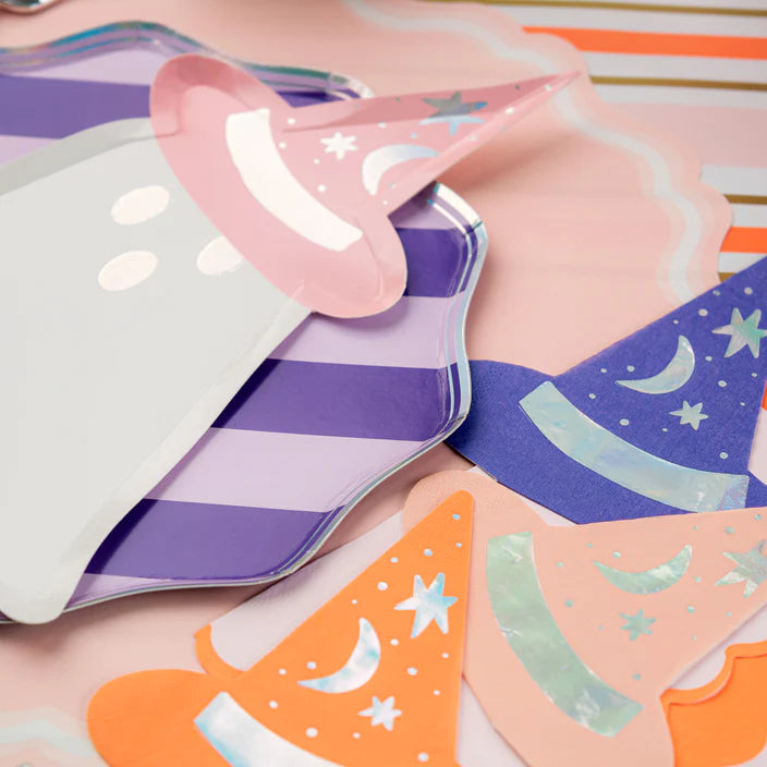 Detail view of ghost plate edge and assorted witch hat napkins on a pastel table.