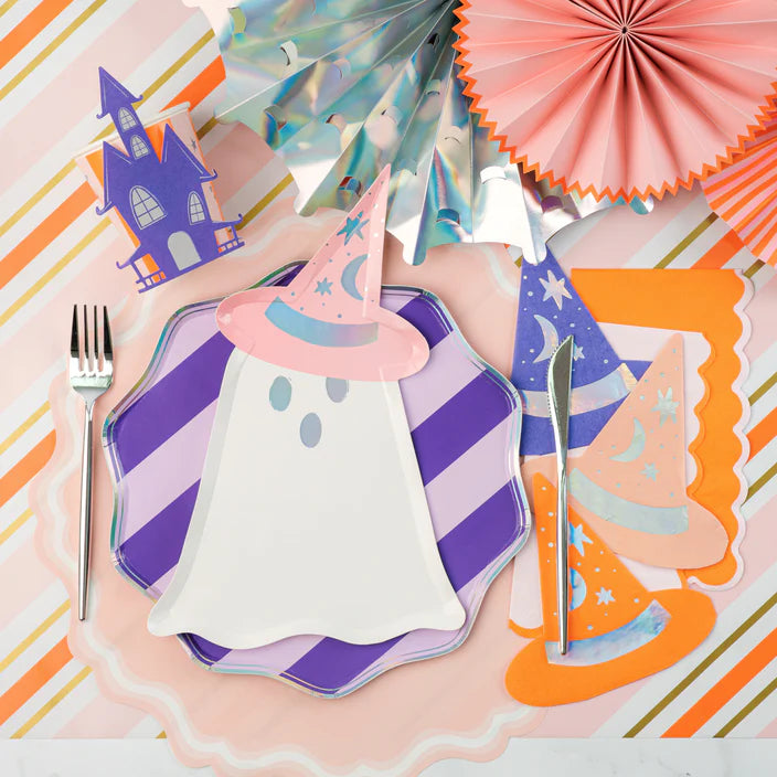 Flat lay place setting with ghost plate, striped border plate, party fans, and hat napkins.