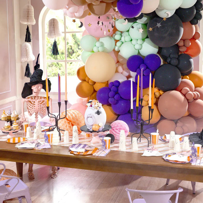 Pastel Halloween tablescape with balloon garland and place settings featuring Bewitching Ghost die cut plates.