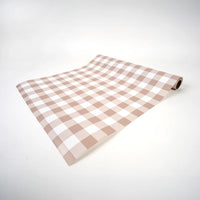Brown gingham table runner partially unrolled to display the taupe and white check pattern.
