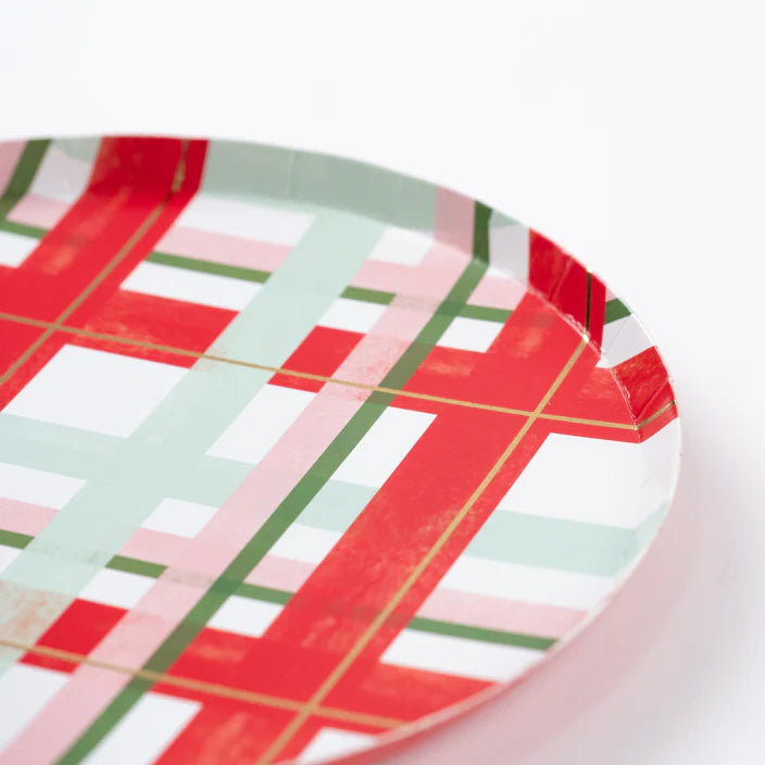 Close view of small paper plate showing red, mint, pink, and forest green holiday plaid.