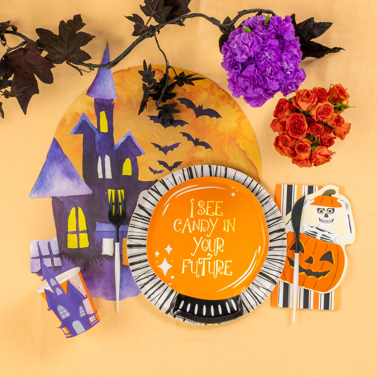 Halloween place setting with crystal ball plate on black and white rim plate beside haunted house placemat and flowers.