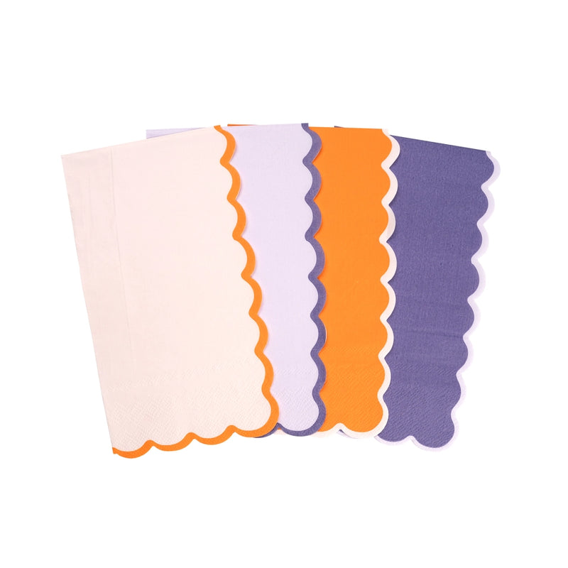 Four scalloped guest towels overlapped to show colors white with orange border, lilac with purple border, orange with white border, and purple with lilac border.