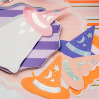 Ghost plate on purple striped plate with an orange guest towel and extra witch hat napkins arranged on a pink striped runner.