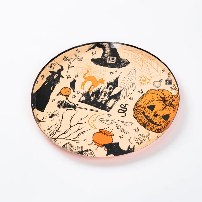 Three quarter view of round plate covered in hand drawn Halloween icons on peach background.