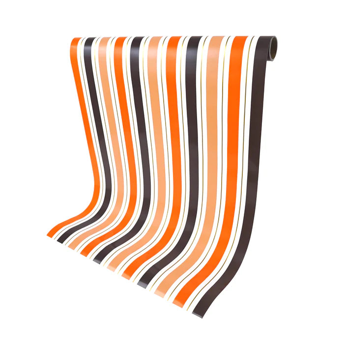 Halloween stripe paper table runner draped from the roll to display length.