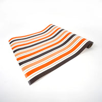 Halloween stripe runner partially unrolled to show pattern and paper finish.