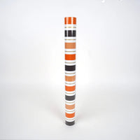 Product shot of Halloween stripe paper table runner rolled in a tube.