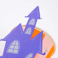 Close view of haunted house topper leaning on the pink and orange striped cup.