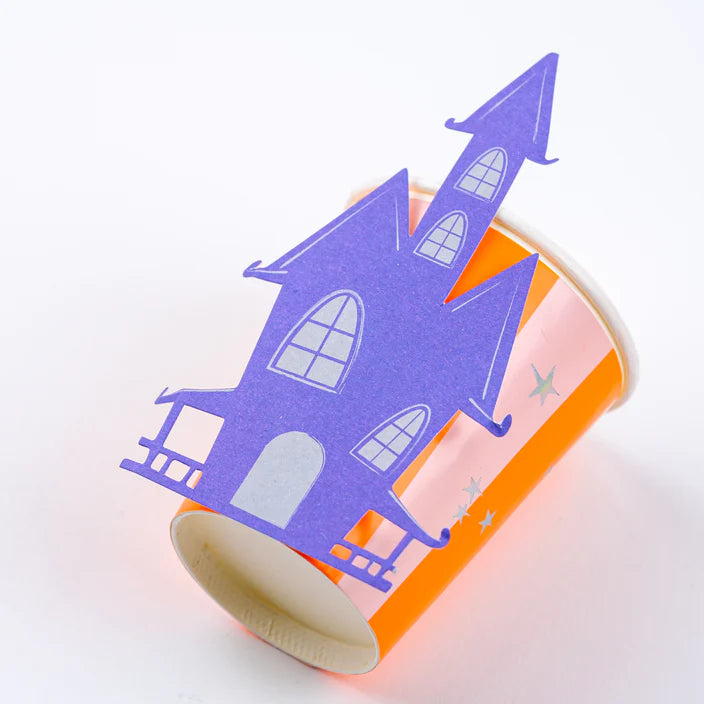 Macro of windows and roof lines on the purple haunted house topper over a striped cup.
