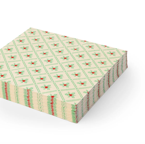 Stack of holly-patterned lunch Christmas paper napkins with green lattice and red berries
