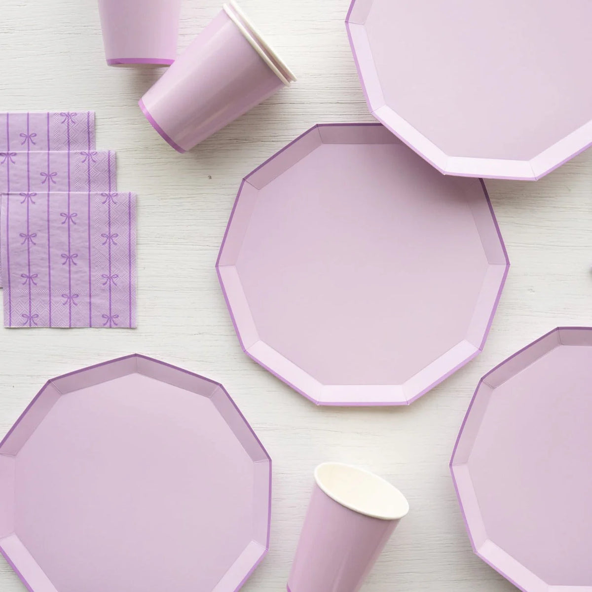 Closeup group of lilac plates with matching cups and purple paper napkins