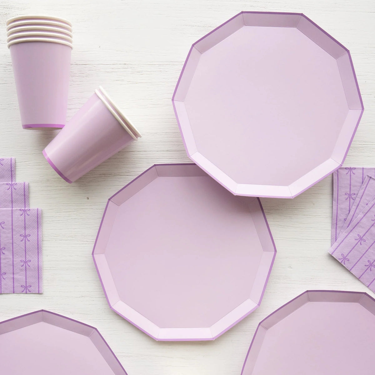 Overhead detail of lilac plates and cups with bow-pattern napkins
