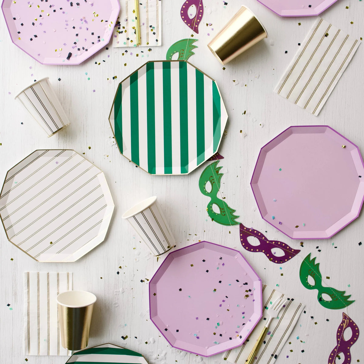 Party flatlay showing lilac plates mixed with green stripe and gold accents
