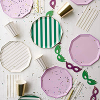 Party flatlay showing lilac plates mixed with green stripe and gold accents