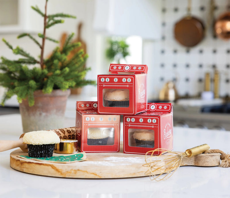Trio of red oven Christmas treat boxes with clear windows on kitchen counter