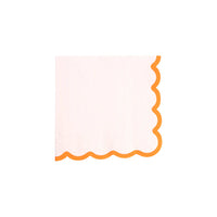Single creamy white cocktail napkin with orange scalloped border on white background.
