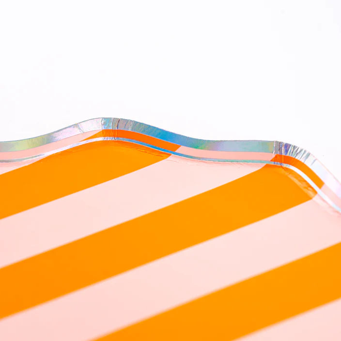 Corner macro of orange striped dinner plate showing scalloped edge and iridescent trim.