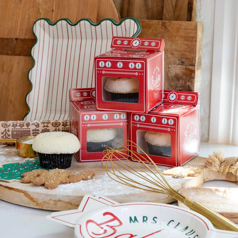 Holiday baking scene with oven treat boxes and green tree cookie napkin on board