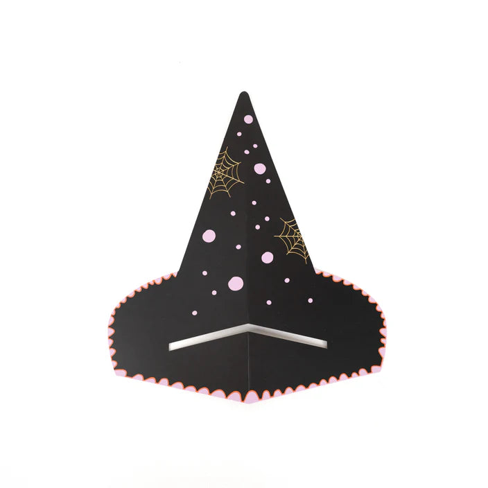 Witch’s hat napkin holder styled on layered striped plates with scalloped edge napkin tucked underneath.