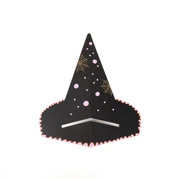 Witch’s hat napkin holder styled on layered striped plates with scalloped edge napkin tucked underneath.