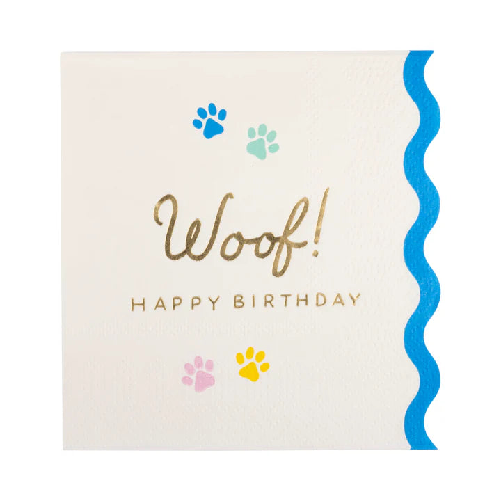 Product image of Woof Happy Birthday cocktail napkin with paw prints and blue scallop edge.