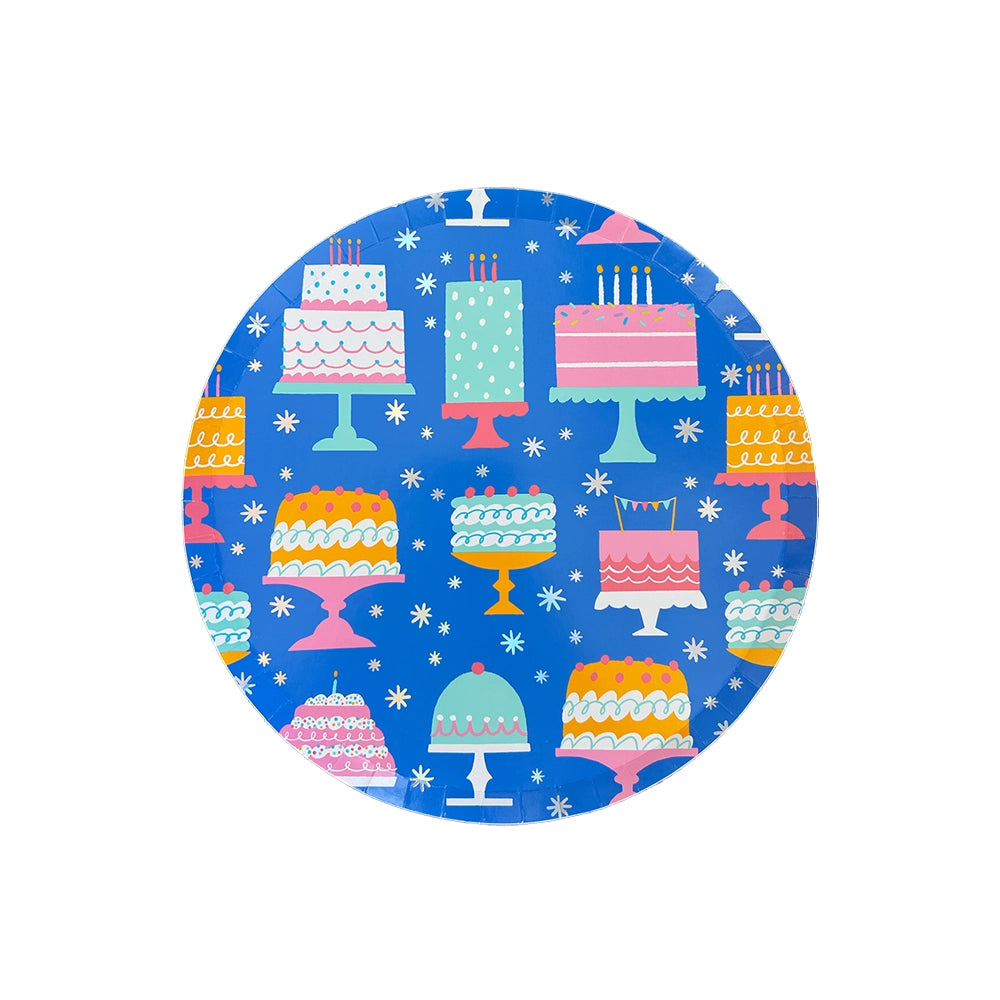 Studio image of 7.5-inch blue paper plate with colorful birthday cake pattern on bright blue background