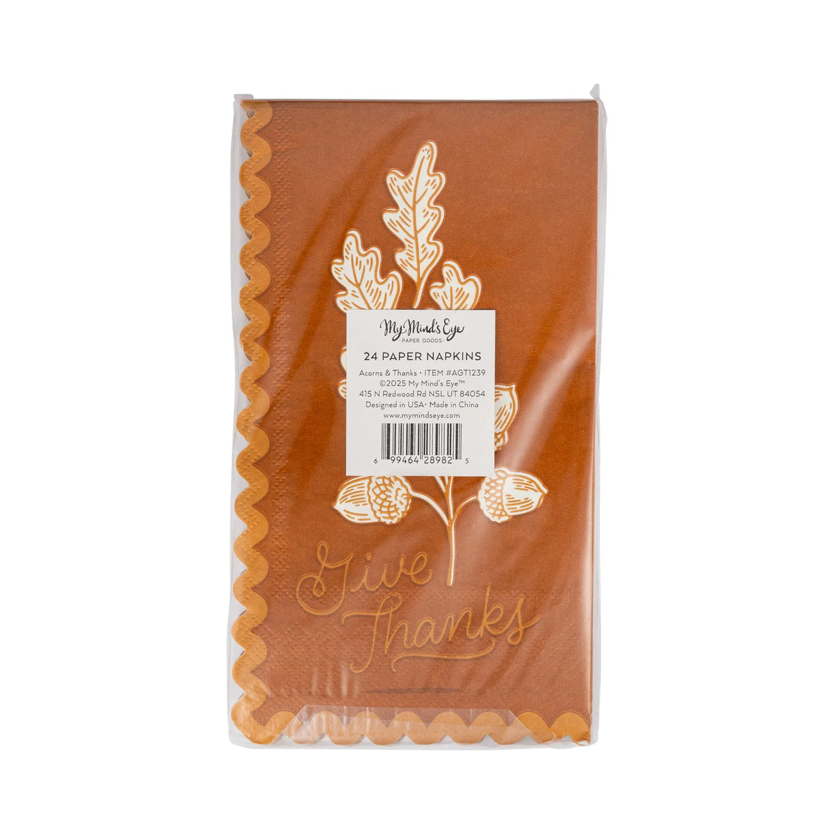 Rust dinner napkin with white oak leaves, acorns, and “Give Thanks” script, scalloped edge