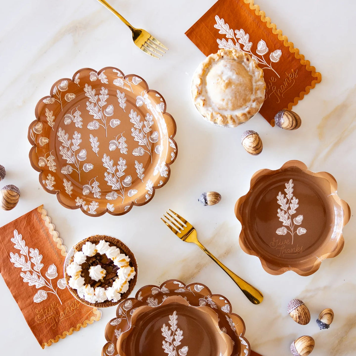 Thanksgiving place settings with coordinating acorn plates and rust dinner napkins