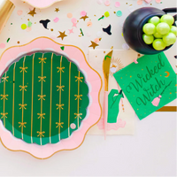 Tablescape with green Wicked Witch cocktail napkin and wand theme accents, styled for a Wicked theme party using Halloween party napkins