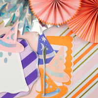 Haunted house cup and witch hats next to ghost plate over the pink table runner