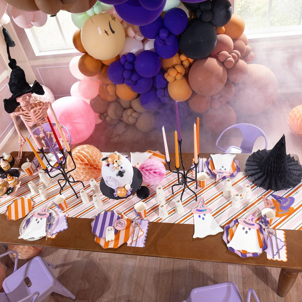 Party room with balloons and long table dressed in pink table runner stripes