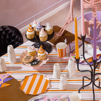 Cupcakes and ghost décor on orange and pink striped paper table runner
