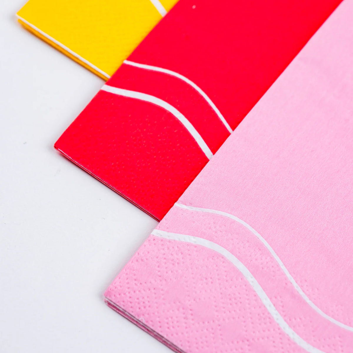 Close detail of red and pink guest towels with white wavy lines