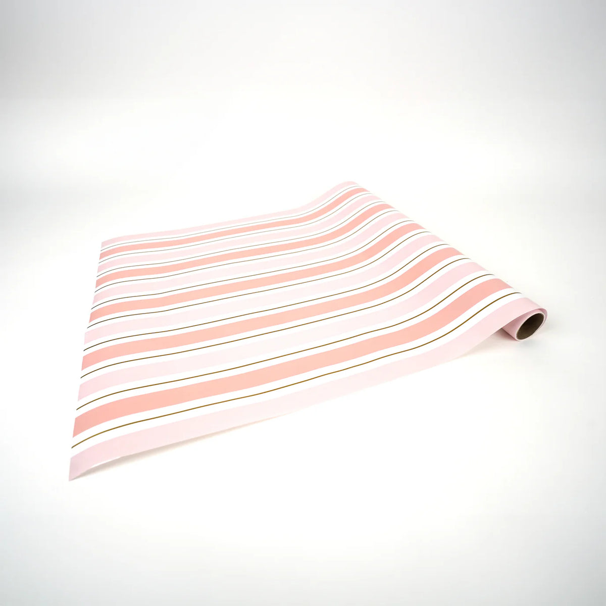 Pink striped paper table runner unrolled flat on white surface