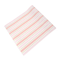 Angled view of pink striped paper table runner sheet, blush bands and gold lines